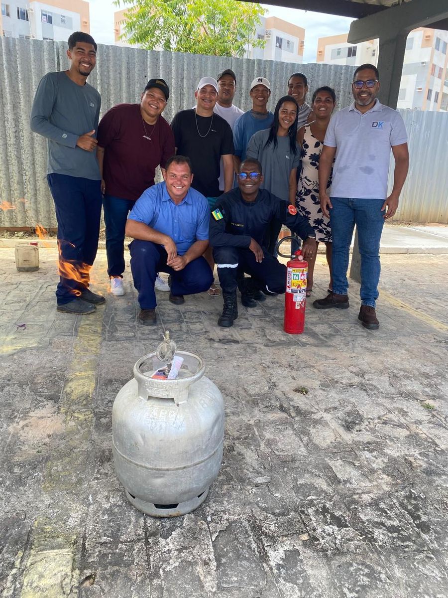 Grupo de participantes reunido após o treinamento, ao lado de extintor e botijão